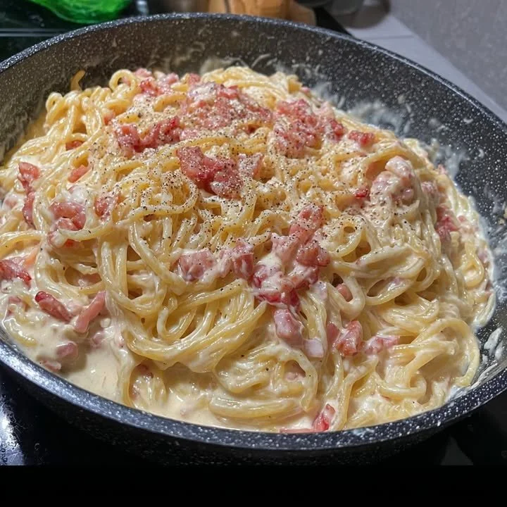 Delicious Carbonara Pasta garnished with cheese and parsley on a plate