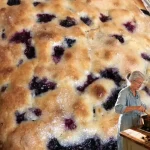 Delicious berry lemon bars topped with fresh berries and a dusting of powdered sugar.