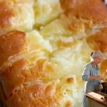 Easter carrot cake topped with cream cheese frosting and decorative carrots.