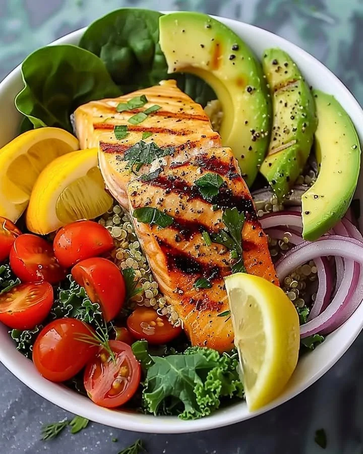A vibrant grilled salmon power bowl topped with fresh veggies and grains