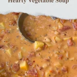 Bowl of hearty vegetable soup filled with colorful vegetables and herbs