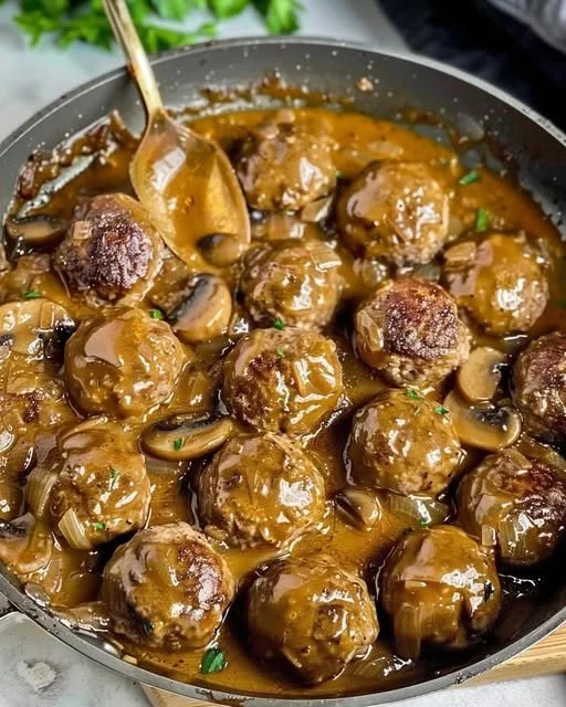 Delicious meatballs coated in a rich mushroom sauce served in a bowl.