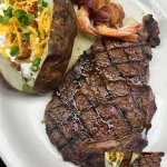 Juicy grilled steak served with herbs and spices, showcasing the perfect steak cooking techniques.