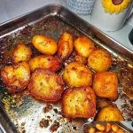 Golden crispy roast potatoes served in a bowl, ideal for dinner sides.