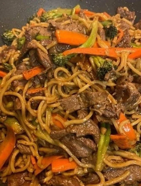 A delicious plate of homemade beef lo mein with colorful vegetables and tender beef.