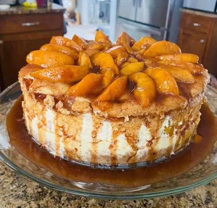 Peach Cobbler Cheesecake topped with fresh peaches and a crumbly crust